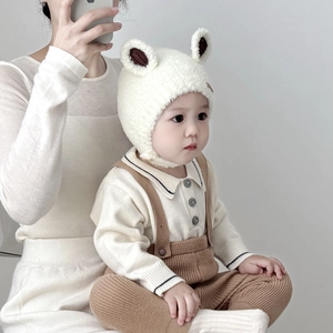 Detail of white plush baby winter hat with cute ears and soft fleece earflaps