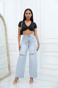 Close-up of light blue high-waist wide-leg jeans with stylish ripped knee details