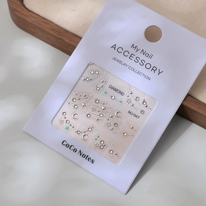 Close-up of French style nail art stickers with crystal rhinestones and gold lines