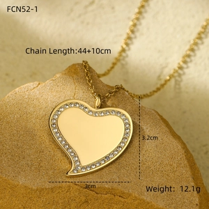 Detail of gold heart necklace with white crystals on stone base, showing 44+10cm length