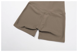 Close-up of ribbed high-waist yoga shorts showing seamless knitting and coffee fabric texture