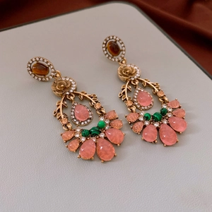 Macro detail of vintage floral earrings with tiger eye stones and pink water drop gems