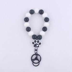 Detail of beaded silicone wristlet keychain with black and white paw print pendant
