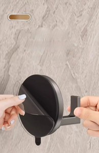 Installing a black suction cup hook by peeling off the protective film for easy setup