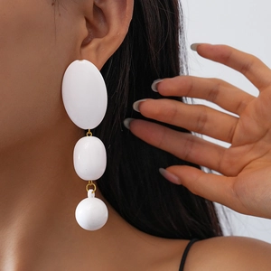 Boucles d'oreilles géométriques en acrylique à perles avec anneaux dorés sur modèle