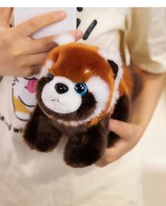 Close-up of plush red panda toy with fluffy fur and sparkling blue glitter eyes