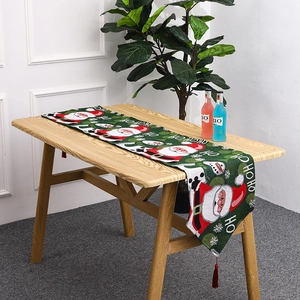 Close-up of Christmas table runner with Santa motifs and festive red tassels