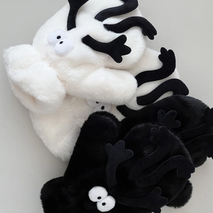 Close-up of soft plush monster gloves in black and white with cute cartoon eyes
