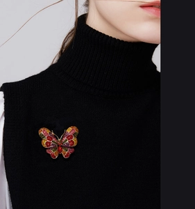 Detail of colorful butterfly brooch with rhinestones on a black turtleneck sweater