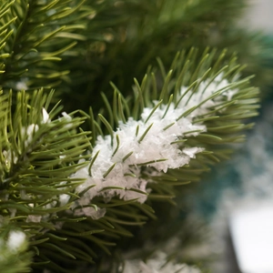 Artificial Christmas tree branch with green needles and realistic snow powder decor