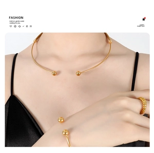 Detailed view of polished 18K gold plated titanium necklace, bracelet, and ring set