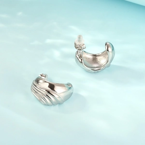 Macro shot of silver seashell textured stud earrings featuring S925 engraved details