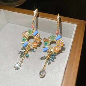 Macro detail of floral zircon earrings with colorful beads and crystal drops