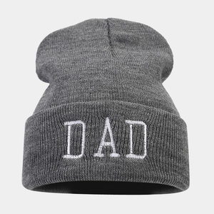 Close-up of the dark grey knitted beanie showing detailed texture and white DAD embroidery