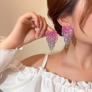 Detailed close-up of gradient heart tassel earrings with sparkling rhinestones on model