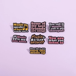 Set of 7 creative black enamel music pins with motivational quotes on purple background