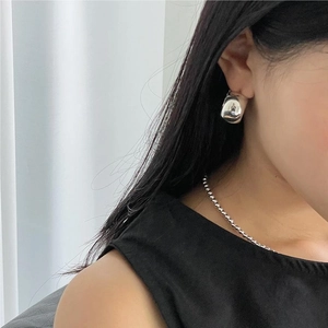 Minimalist 925 sterling silver drop earrings with high-polish metallic finish on model