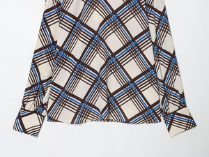 Détail de la manchette et de l'ourlet d'une chemise à carreaux marron et bleu ciel chic