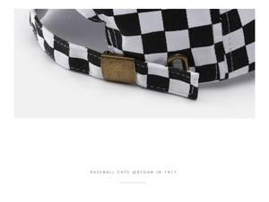 Detailed macro view of black and white checkered baseball cap with adjustable metal buckle