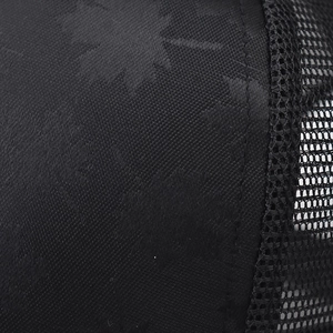 Close-up of maple leaf jacquard pattern on black mesh baseball cap fabric