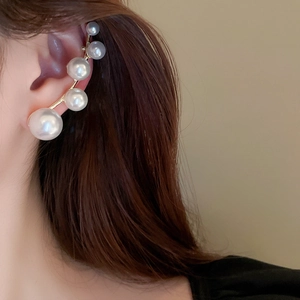 Close-up of elegant gold gradient pearl ear cuff worn by a model in a French chic style
