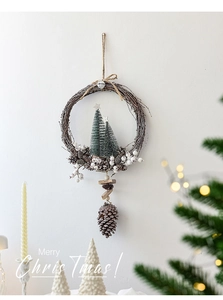 Detail of Christmas wreath with pine cones and white berries on white wall background