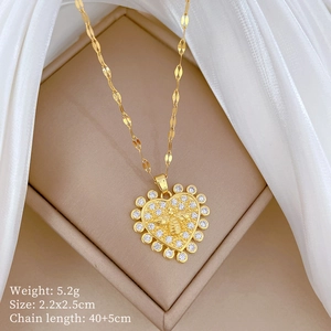 Macro shot of gold heart necklace with bee detail in a jewelry box with size parameters