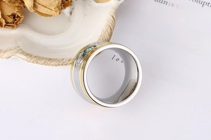 Macro shot of two-tone stainless steel ring with blue gemstone and pavé setting