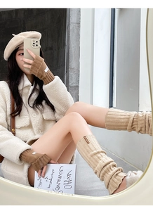 Detail of wool knit leg warmers and fingerless gloves set in elegant beige color