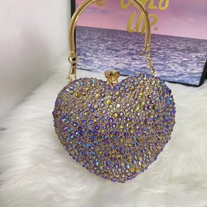 Macro shot of heart-shaped luxury evening bag with multi-color AB rhinestones and gold handle