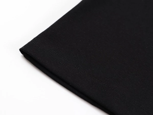 Detailed close-up of double-stitched hem on a black ribbed knit athletic tank top