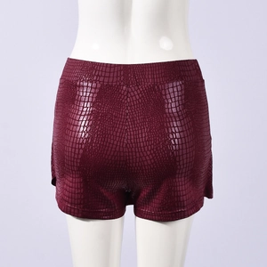 Macro detail of the wine red faux leather texture on these stylish stretch mini shorts