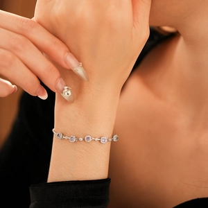 Close-up of elegant silver bracelet with five purple square zircons on female wrist