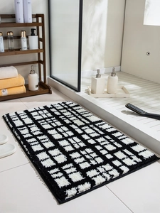 Close-up of thick plush bathroom mat with black and white checkered absorbent texture