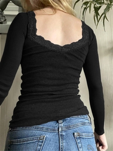 Dettaglio della maglia nera a costine a maniche lunghe con pizzo sulla scollatura dietro