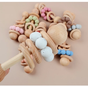 Macro shot of natural beech wood rattle with pastel silicone beads for infant teething relief