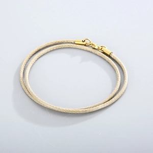 Close-up of beige braided cord necklace with a polished gold lobster clasp closure