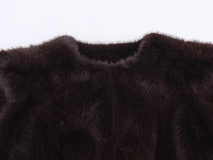 Detalle macro de la textura de piel sintética marrón oscuro en el cuello de la chaqueta