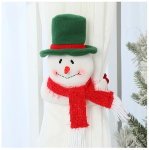 Close-up of a plush snowman curtain tieback on white fabric with festive green accents