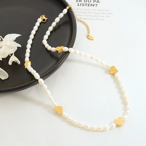 Baroque natural freshwater pearl necklace featuring five gold heart-shaped pendants