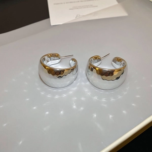 Detailed shot of silver textured C-hoop earrings with irregular hammered pattern finish