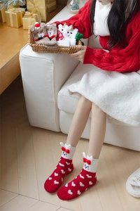 Plush Christmas coral fleece socks with bunny ears and hearts in a gift basket display