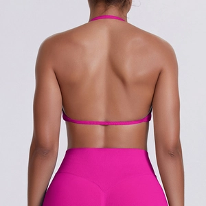 Rear view of pink halter sports bra and high-waist leggings with peach lift stitch detailing