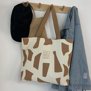 Detail of canvas tote bag hanging on wooden hook with Good Student rabbit print