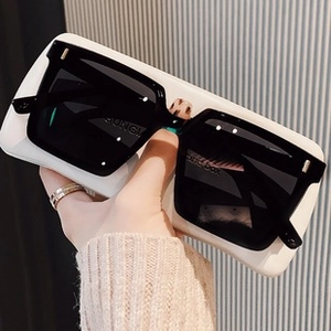 Détail d'une monture de lunettes carrée noire et blanche avec étui blanc assorti
