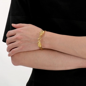 Detail of a vintage golden dragon head bracelet with woven bone chain on wrist