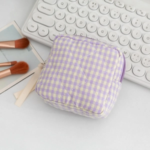 Detail of quilted purple and yellow gingham makeup bag with chic white ribbon zipper