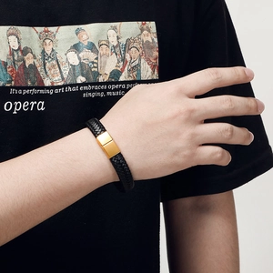 Men's black braided leather bracelet with a matte gold magnetic steel clasp on wrist