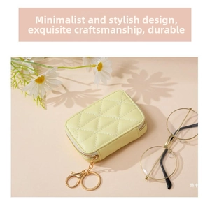 Close-up of quilted lemon yellow cosmetic bag with gold zipper and keyring chain