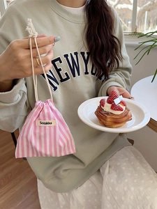 Pink and white striped drawstring storage bag with cotton rope and fabric label